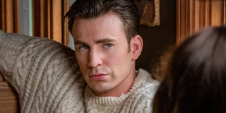 Knives Out Ransom Drysdale (Chris Evans) in sweater sits across from Marta Cabrera (Ana de Armas) in