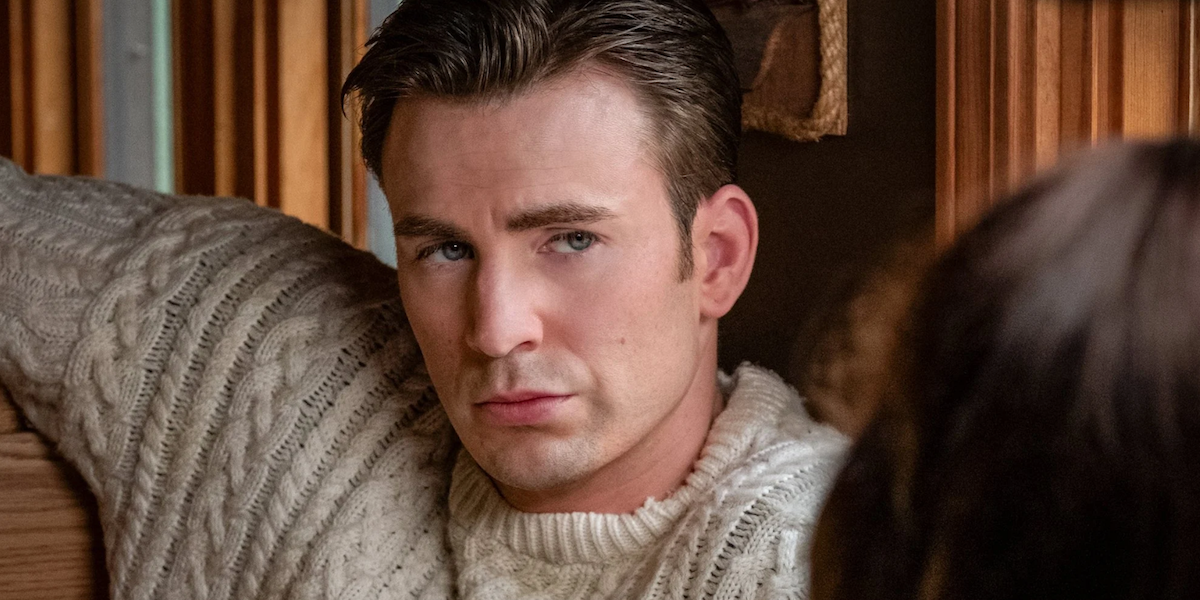 Knives Out Ransom Drysdale (Chris Evans) in sweater sits across from Marta Cabrera (Ana de Armas) in