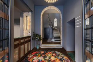 A corridor at the hotel furnished with bright rugs and eclectic art