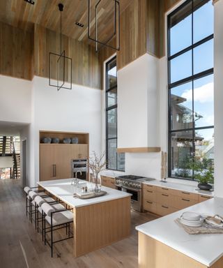 lakeside cabin kitchen with wood cabinets and white countertops and steel framed window