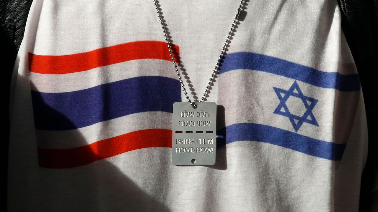 A shot of the Thai and Israeli flags printed on white cloth, with a metal tag with Hebrew writing on it