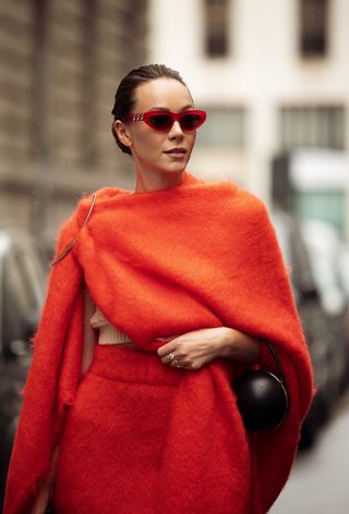 A Woman Wearing Draped Cape During Milan Fashion Week Spring/Summer 2025.