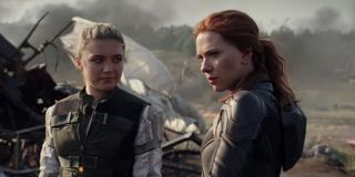 Black Widow Florence Pugh and Scarlett Johansson stand amid some wreckage