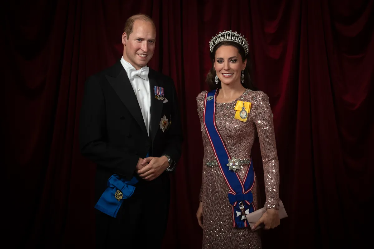 Wax figures of Kate Middleton and Prince William wearing a suit and pink gown with a tiara