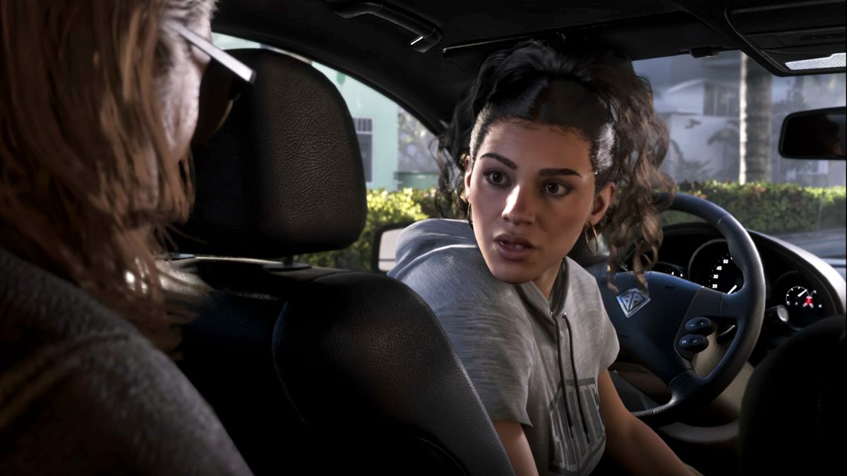 A screenshot of the GTA 6 Extended Look. Lucia sits in the driver's seat of a car and turns back toward a man in the backseat.