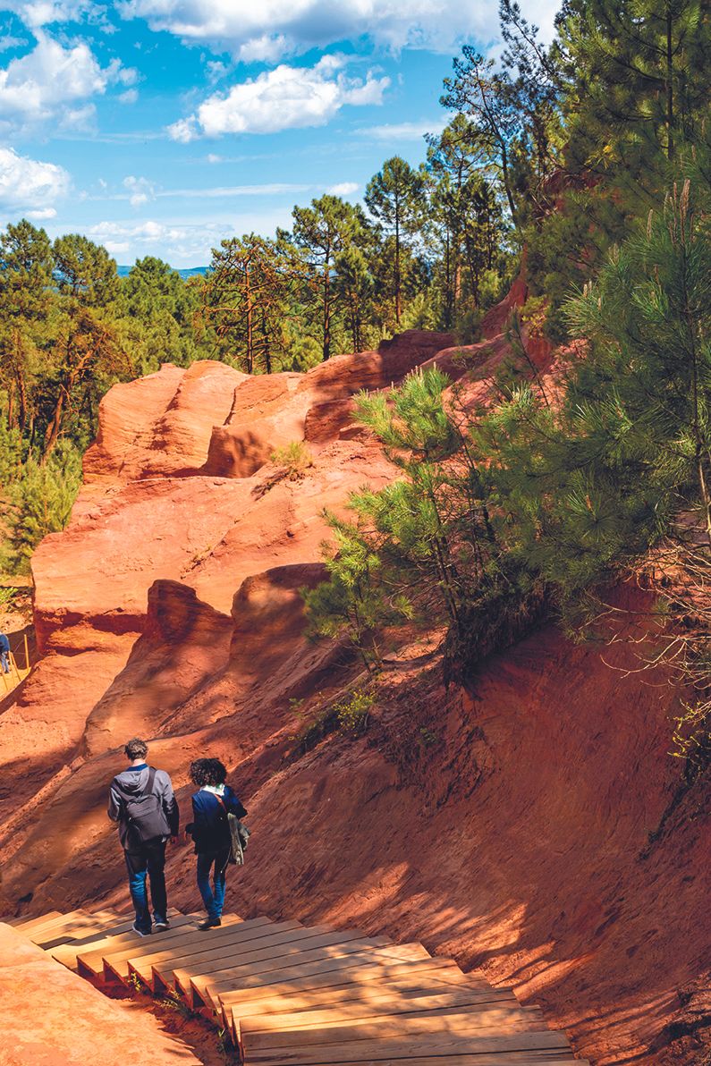 two peolpe walking down a track flanked by rocks