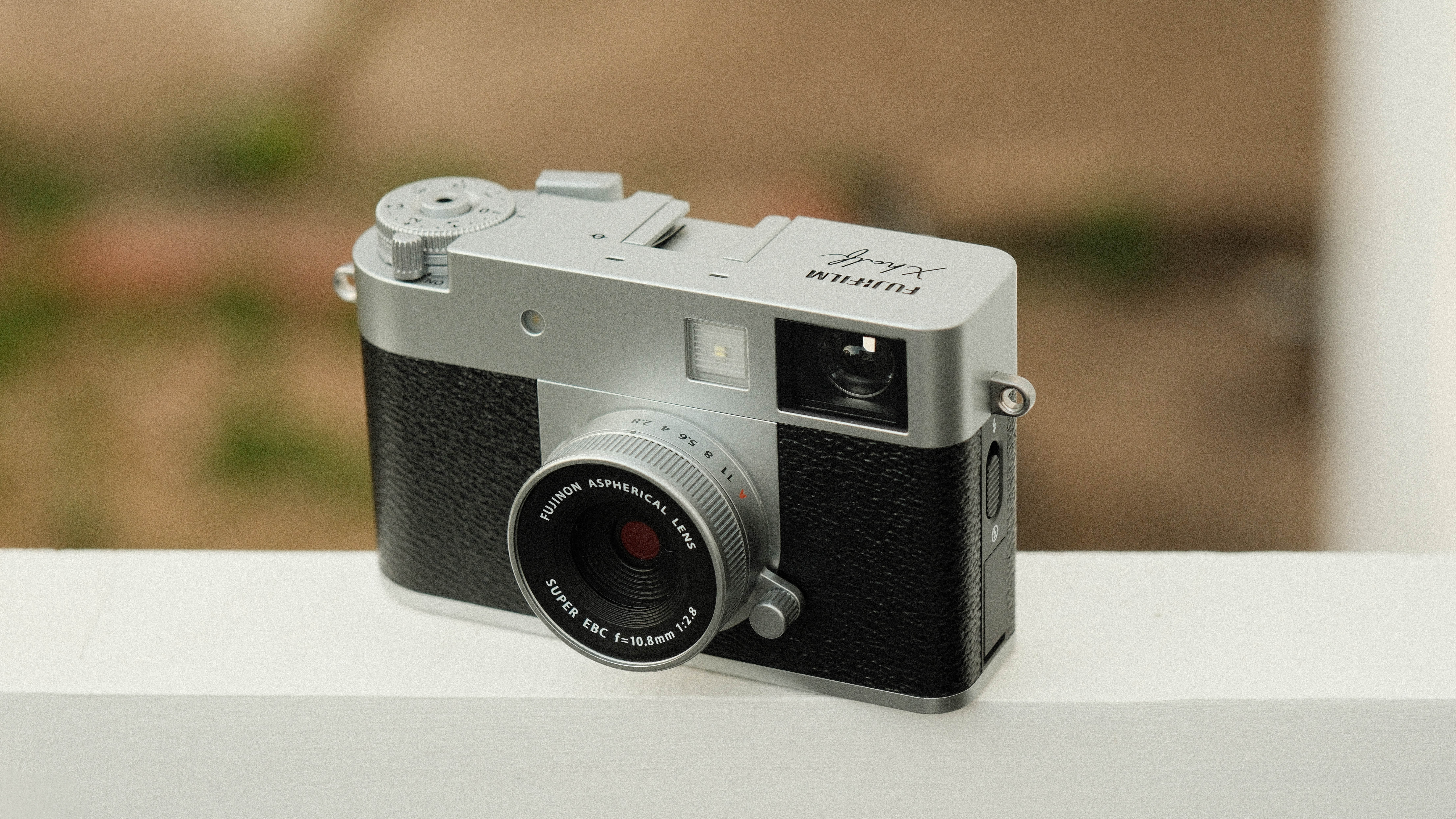 Fujifilm X Half camera balanced on a white bar