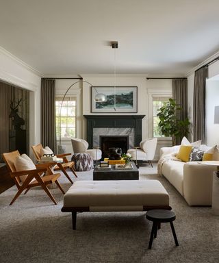 A living room with a white couch, two armchairs, a fireplace, and a framed painting