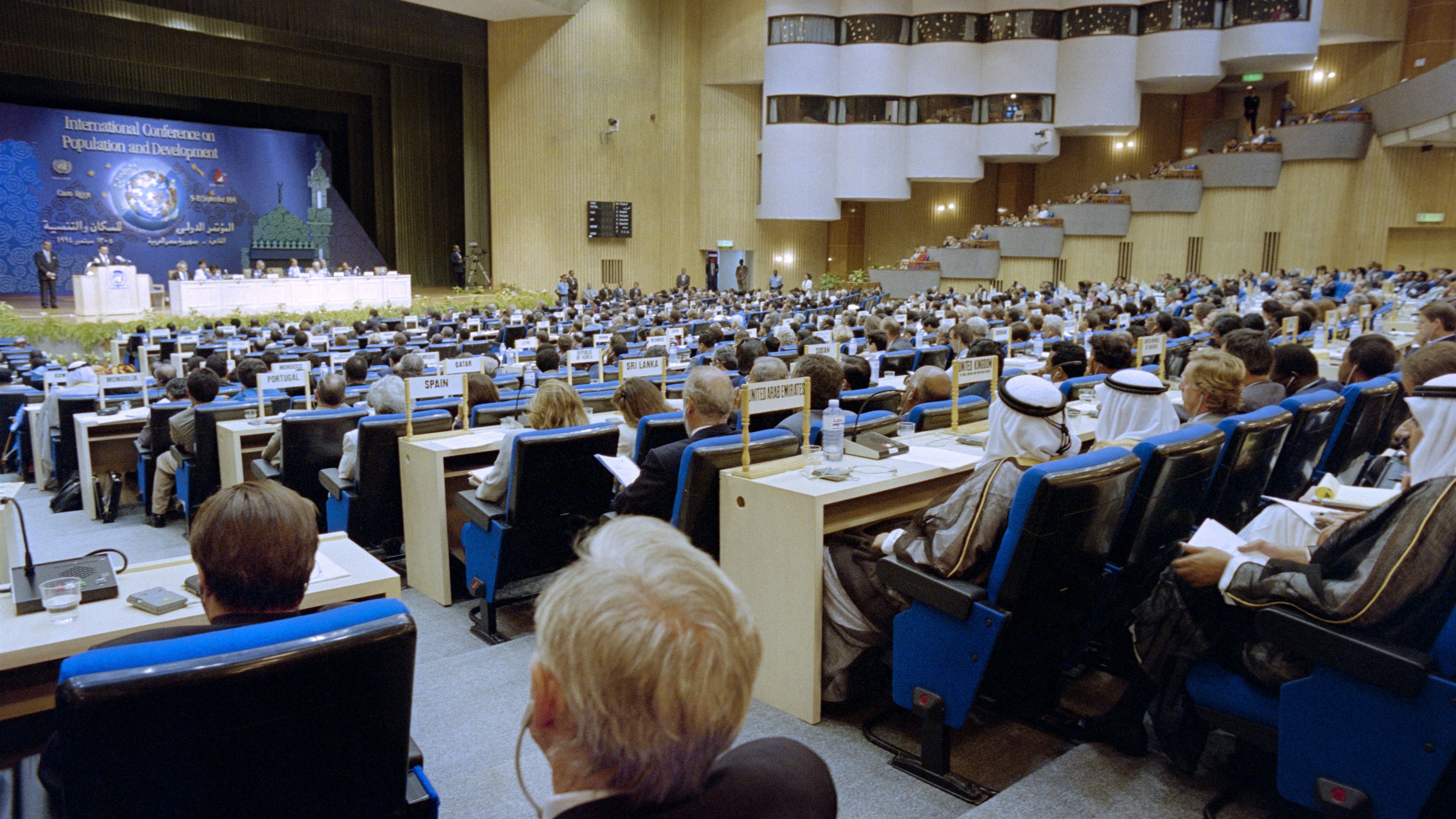 a conference hall filled with delegates facing the stage