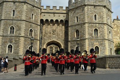 Marching, Public space, Musician, Marching band, Building, Headgear, Musical ensemble, Architecture, Medieval architecture, Palace,