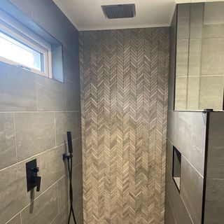 bathroom with small tiles design and black shower
