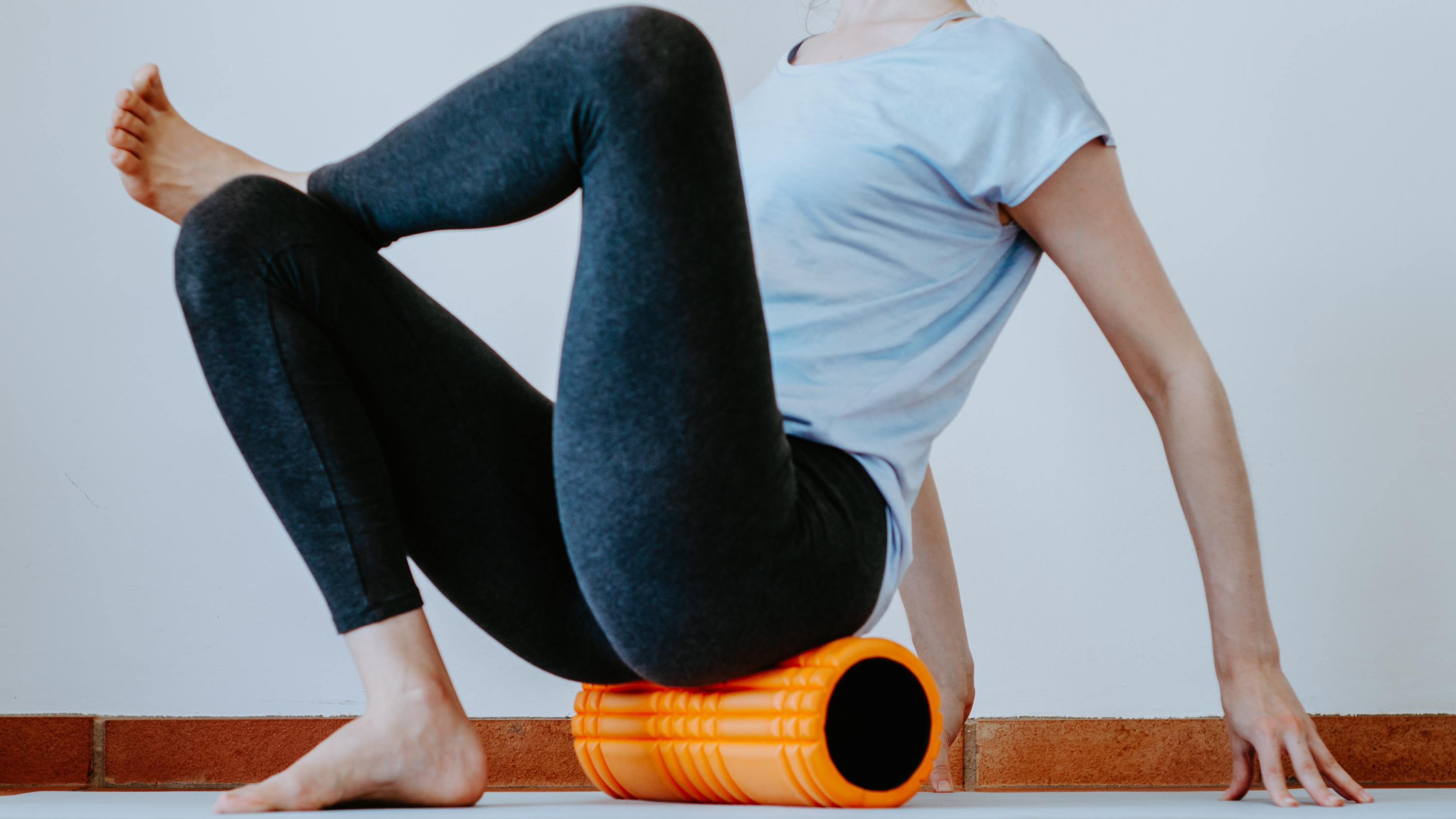 a woman doing the figure four stretch on a foam roller