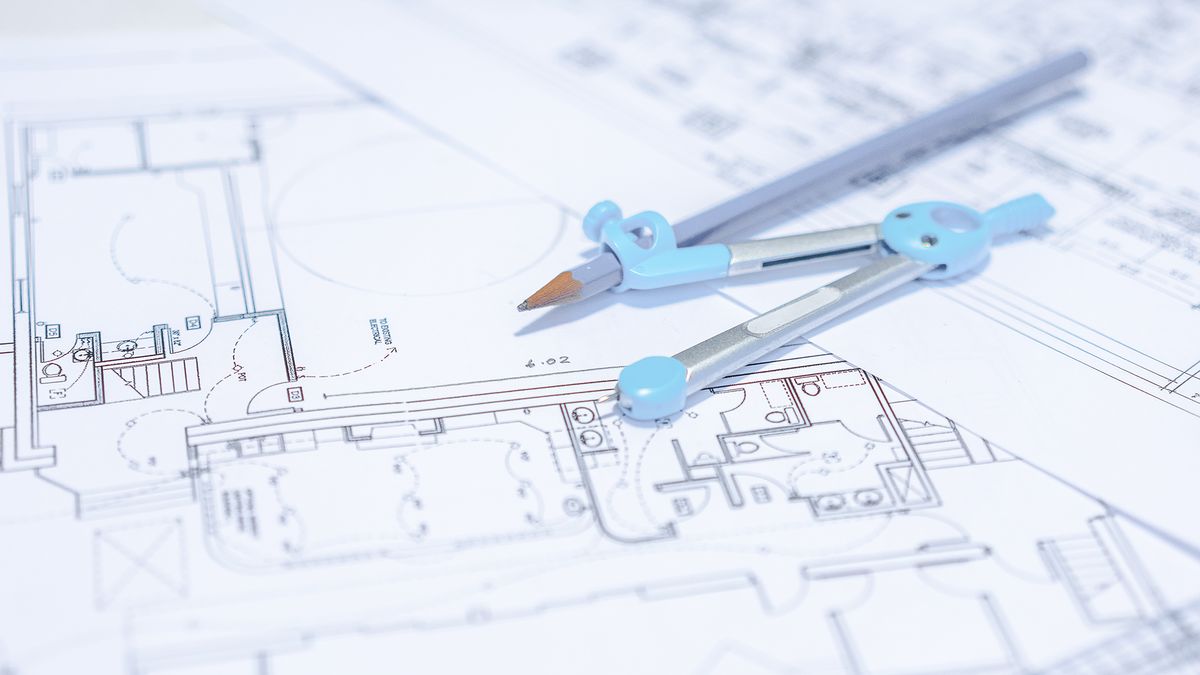 Close-up of blueprint with ruler and drawing compass on table