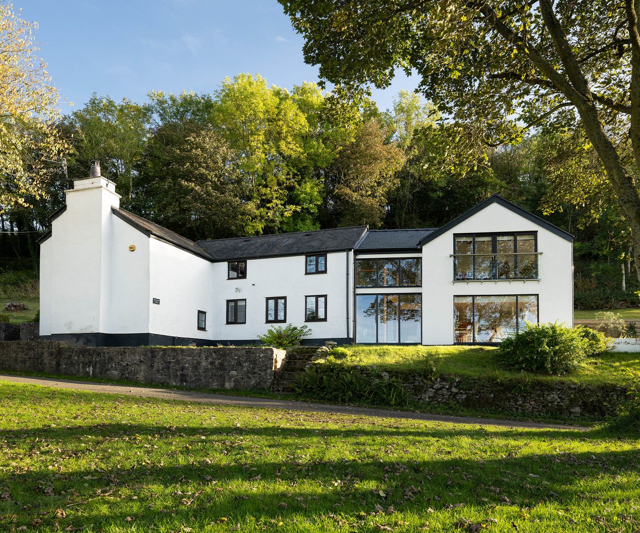 A large double storey extension with large contemporary style glazing and a new white render