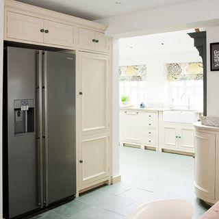 kitchen area with white cabinets and fridge