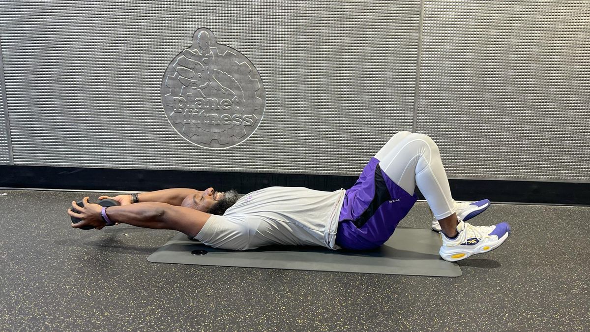 Teddy Savage performing a dumbbell sit-up Russian twist