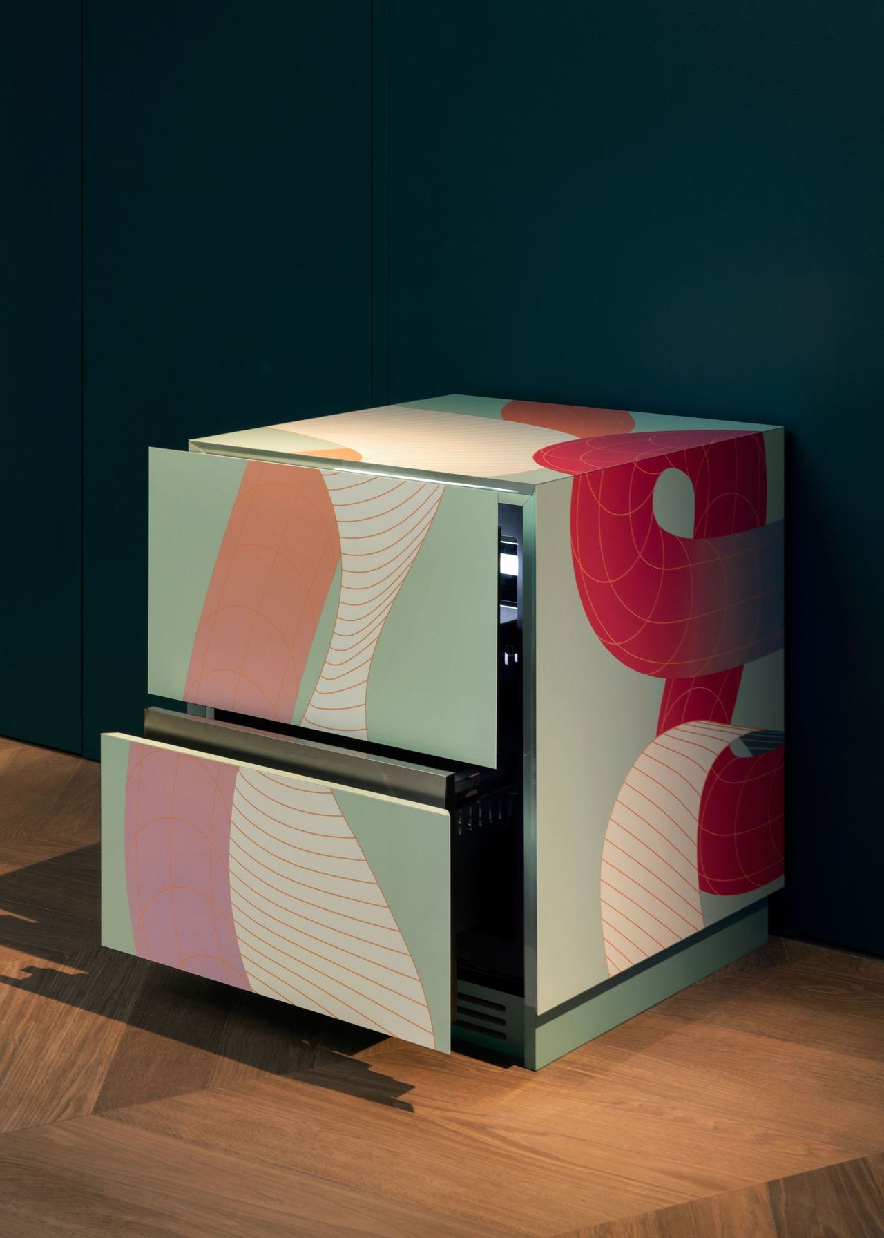 A colorful fridge against a dark wall. The fridge has been crafted with bold and bright tones.