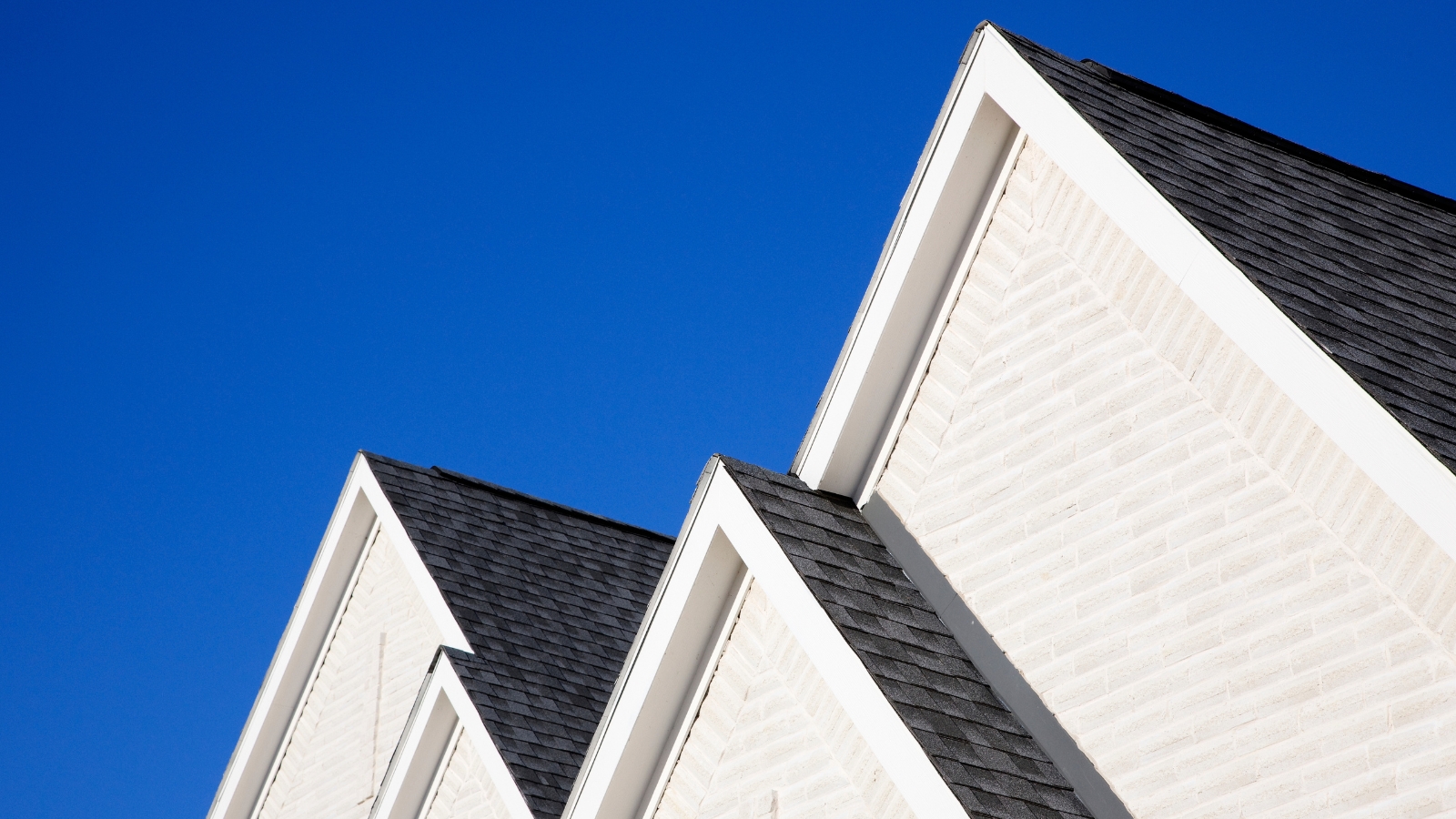 Four gabled rooflines in Texas, USA, with azure blue sky background.