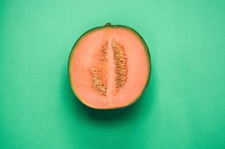 A melon chopped in half that looks like an abstract vulva