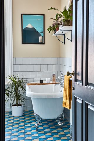 A blue bathroom idea with geometric effect floor tiles and white freestanding bath