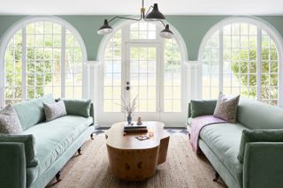 A living room with light green couches and light green walls