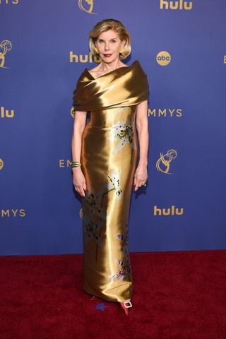 Christine Baranski wears a gold custom Oscar de la Renta dress.