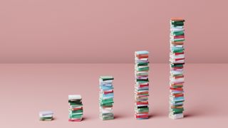 A digital image showing books stacked up in five increasingly large piles to resemble a graph. Decorative: the spines of the books are all different colours and they are set against a pink floor and wall.