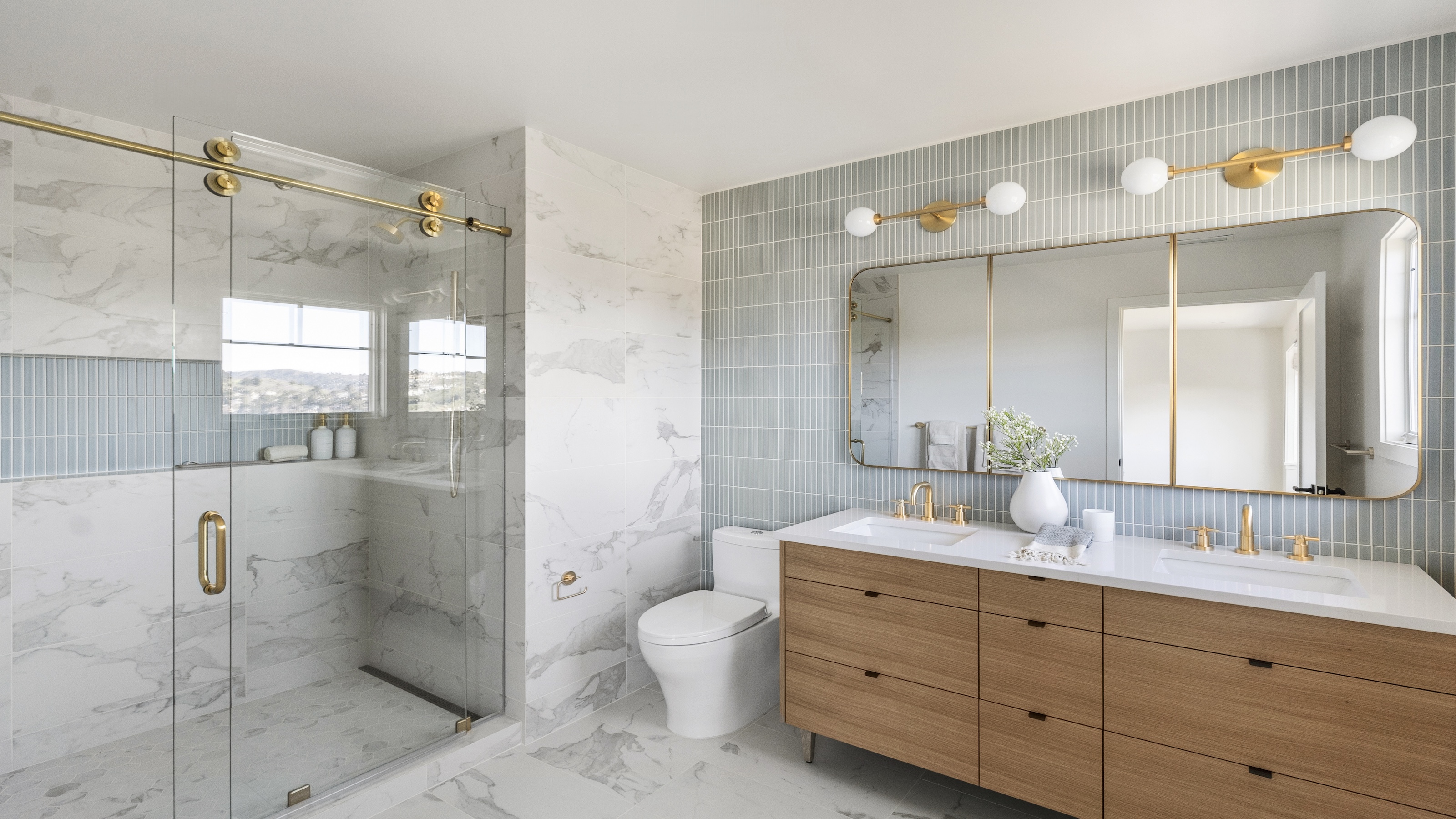 A neat and well organised bathroom with a double vanity showing loads of storage and a large walk-in shower 