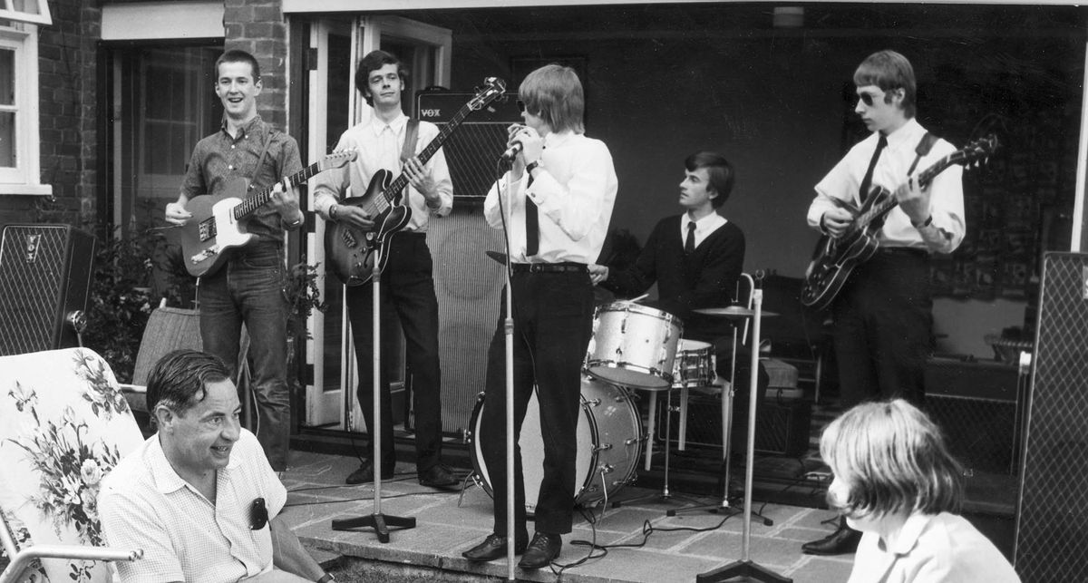 The Yarbirds perform with Eric Clapton on the far left with his Telecaster. British playwright Lord Willis and his daughter Sally watch on from lawnchairs.