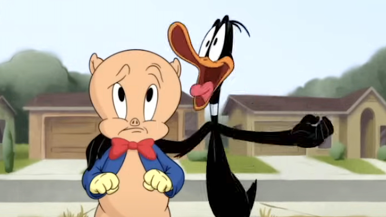 Daffy Duck pone su brazo emocionado alrededor de un cerdo de cerdo preocupado en el día en que explotó la tierra: una película de Looney Tunes.