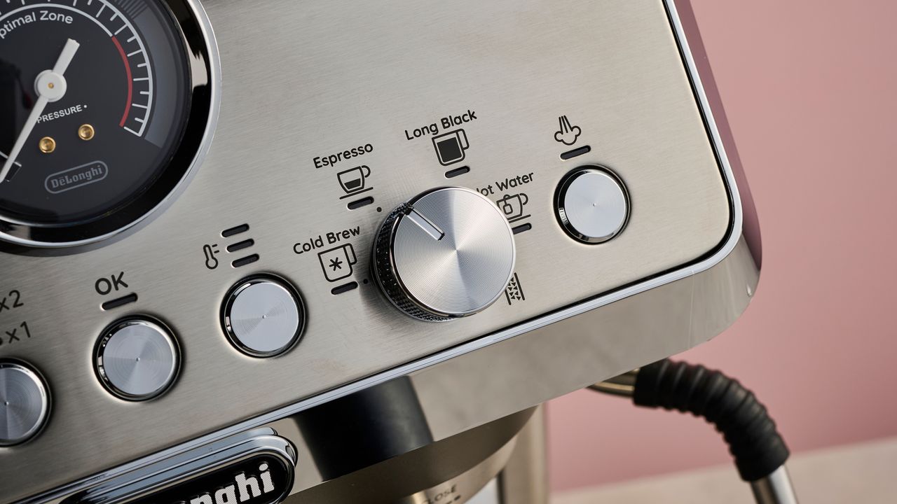 A close-up view of the okay, temperature, and steam arm buttons, along with the dial to select drink types.