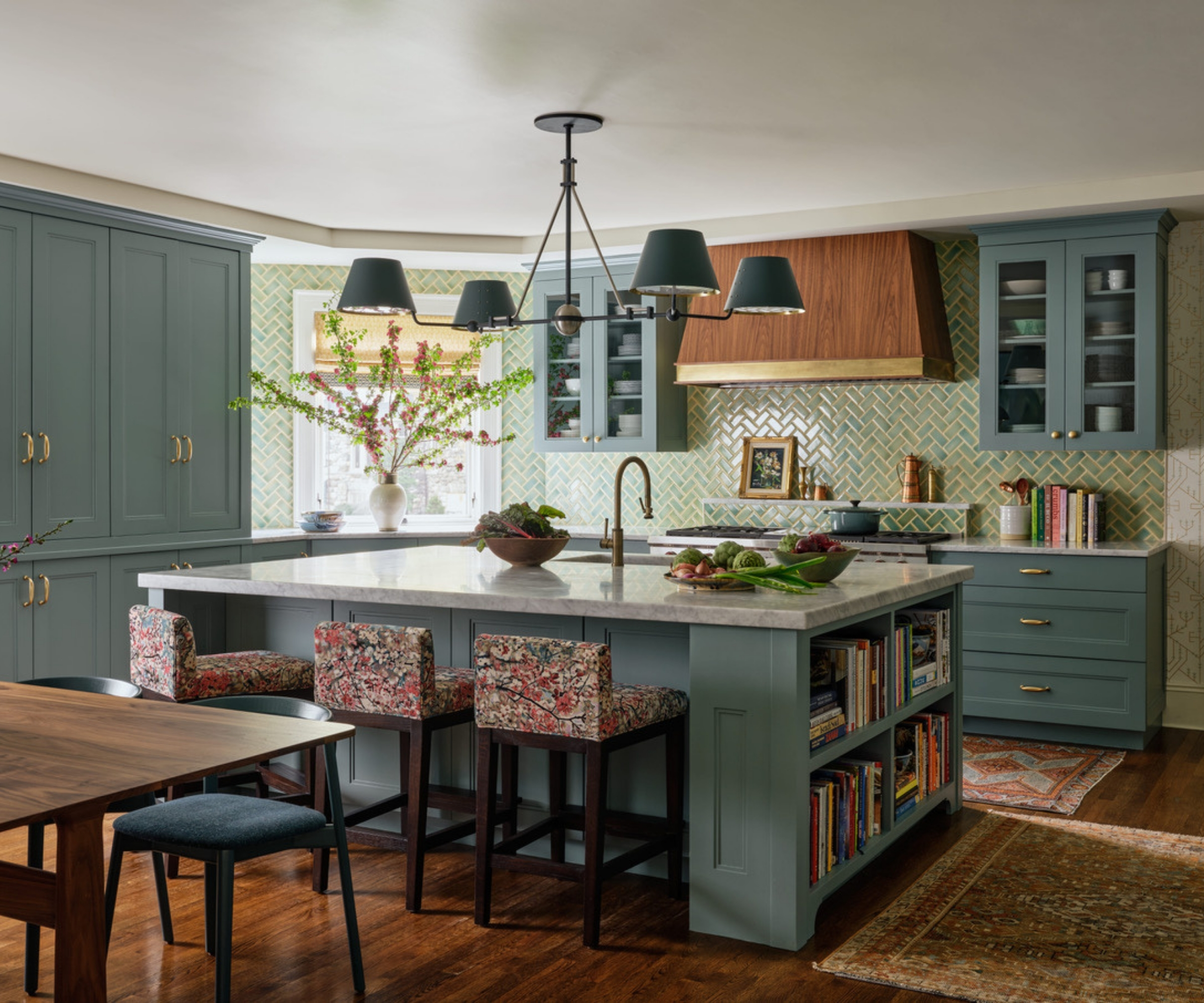 A colorful kitchen with mid-blue cabinets, white countertops, and green tiled herringbone backsplash