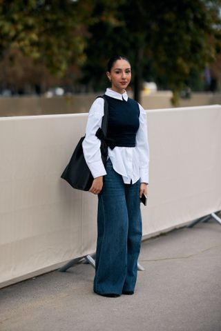 woman wearing baggy jeans , button-down shirt, and sweater vest