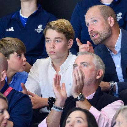 Prince William sitting in the stands at the Commonwealth Games talking to Prince Louis and Prince George