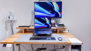 A fully setup Desky Dual Bamboo standing desk with laptop, monitor and peripherals