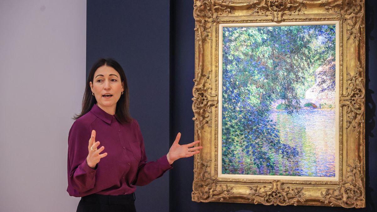 Auctioneer at Christie&#039;s shows impressionist painting 