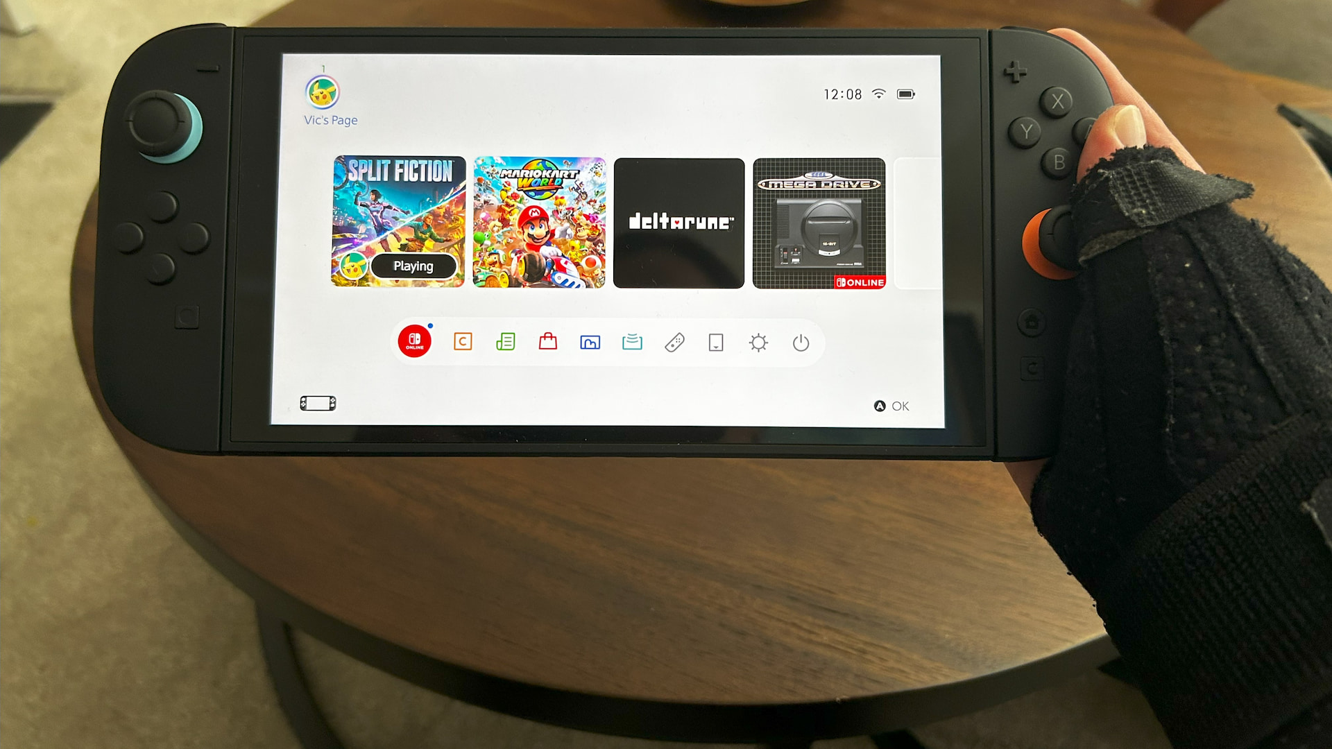 A Nintendo Switch 2 being held by a hand in a support brace