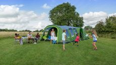 best inflatable tents: large family playing aorund the Coleman Weathermaster XL tent