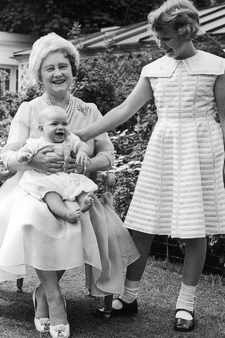 The Queen Mother with her grandchildren in the garden at Clarence House. Princess Anne in white dress and Prince Charles in suit.