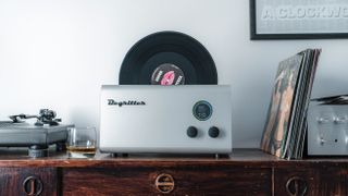 Degritter record cleaning machine next to tuntable and batch of LPs stacked on the right