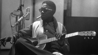 Lightnin' Hopkins seen through the window of the studio while recording his album 'Penitentiary Blues' on July, 6, 1960 in Los Angeles