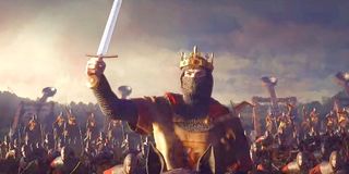A king on a crusade holds his sword aloft.