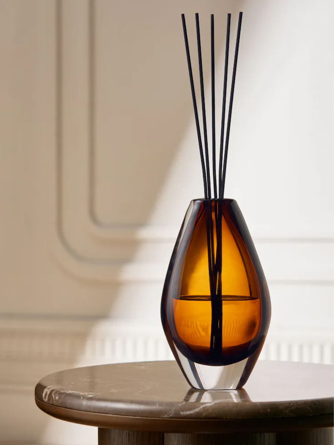 An amber glass reed diffuser with a white tea scent from Next