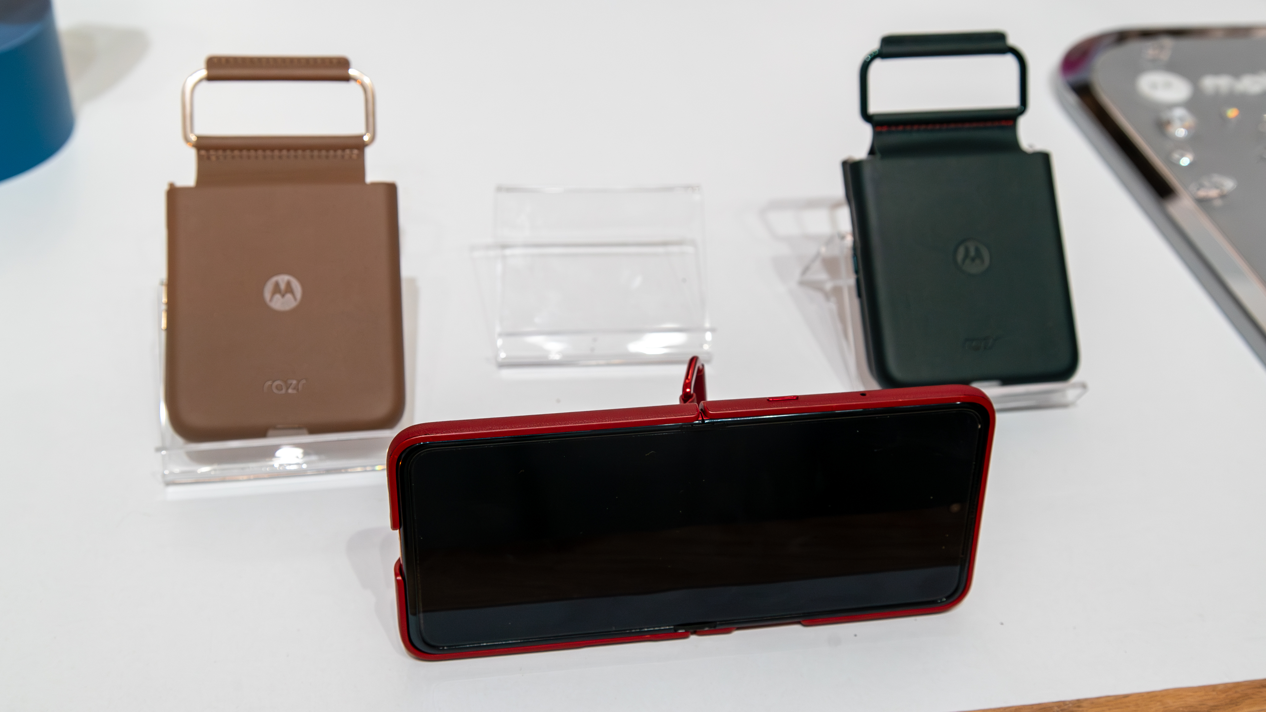 The Razr Ultra 2025 with a ring stand case on and two other cases on either side.