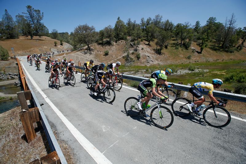 Mark Cavendish leads the peloton over a small bridge