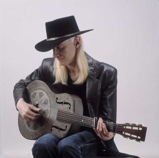 Johnny Winter studio portrait with acoustic guitar