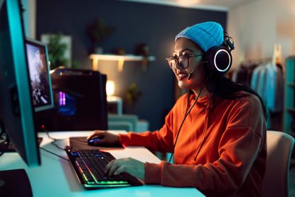 A person gaming using a PC and wearing a headset