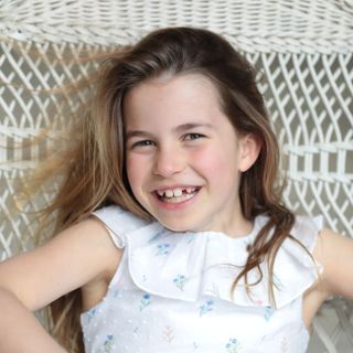 Princess Charlotte smiling widely in a hammock