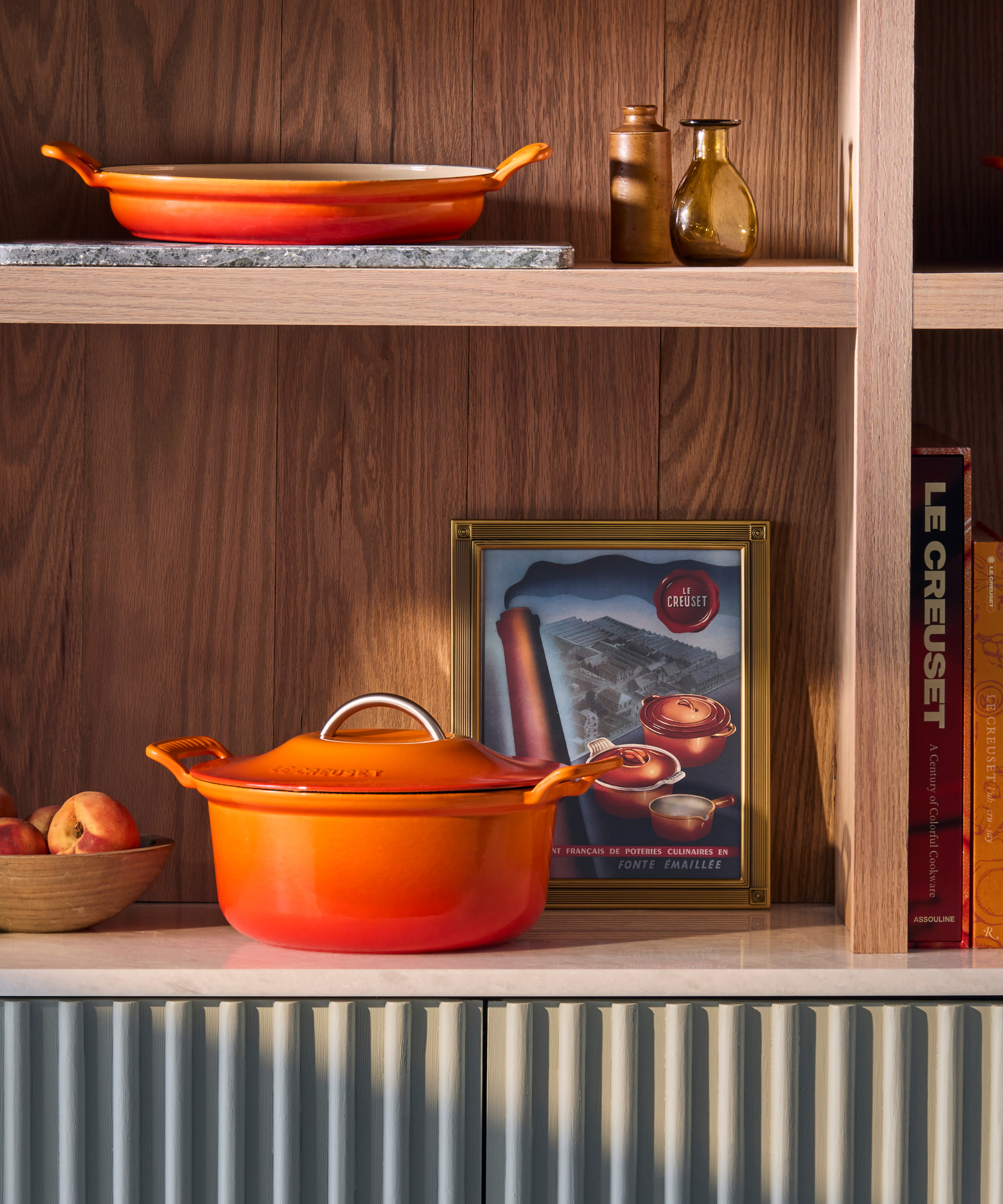Le Creuset's Modern Heritage Braiser and Dutch oven in the classic orange shade on shelves
