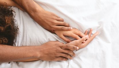 couples hands in bed having sex meant to depict orgasm control